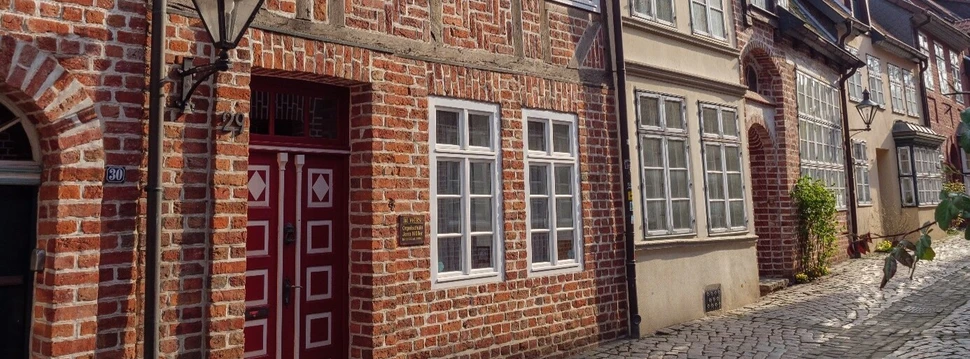 Ein Backsteingebäude mit einer roten Tür