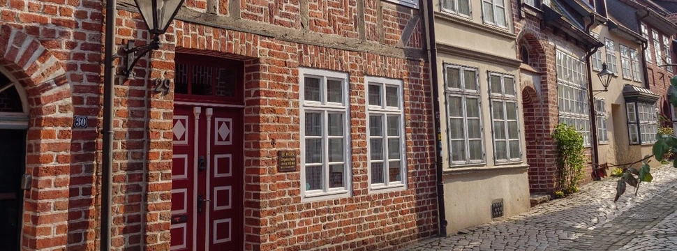Ein Backsteingebäude mit einer roten Tür