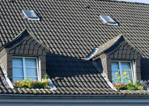 Hausdach mit zwei Gauben und braunen Dachziegeln