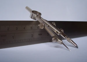 Ein Zirkel lehnt am Linear.