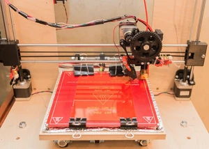 Eine rote Platte in einem Drucker, auf die Sachen eingraviert werden